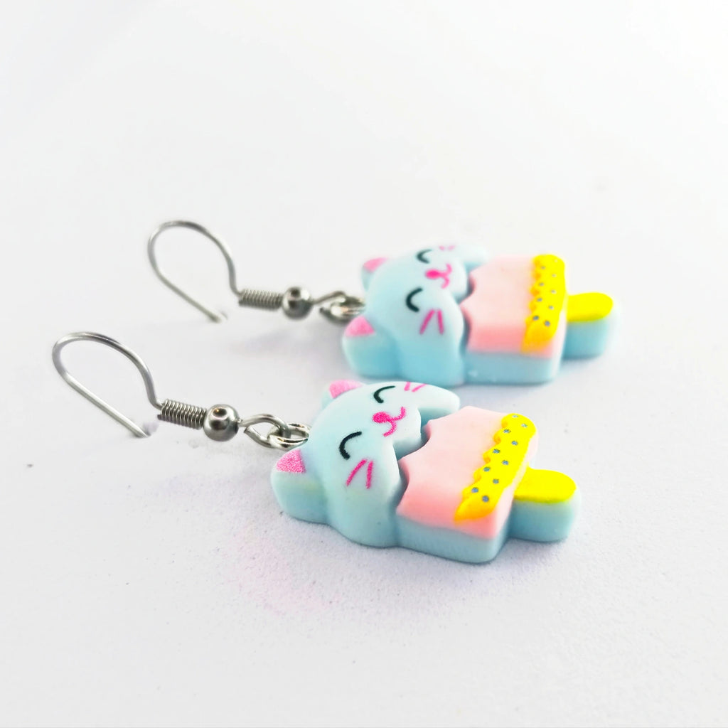 détail boucles d’oreilles chat kawaii glace bleu et jaune en résine finition matte