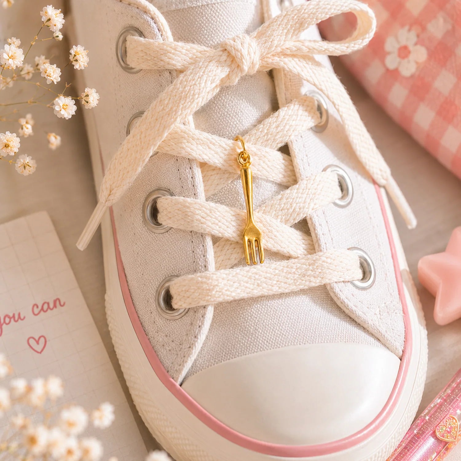 charm fourchette dorée accroché sur des lacets de baskets dans un univers kawaii doux et créatif