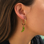 boucle d’oreille créole dorée avec charm haricot petit pois vert porté dans une ambiance douce et lumineuse