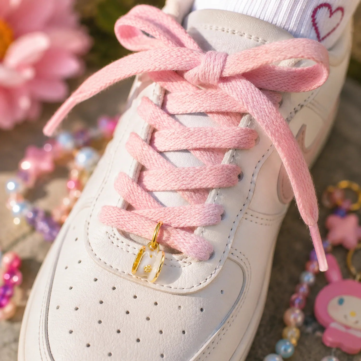 Charm tasse dorée Moka accroché à des lacets de sneakers enfant