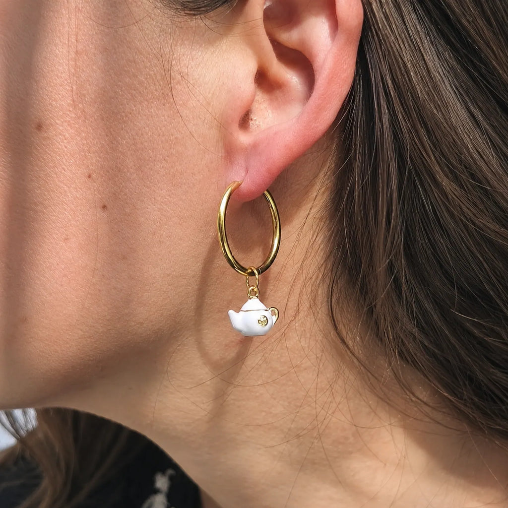 Créoles dorées portées avec charm théière Théa style bijou original